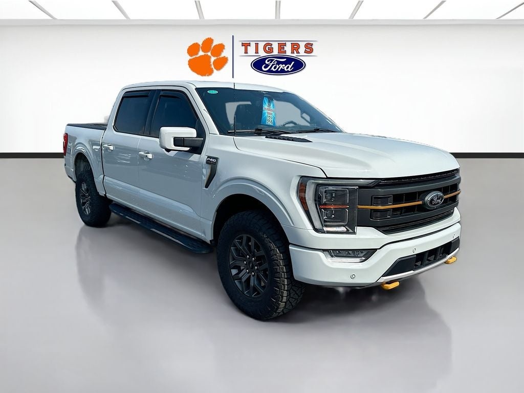 Used White Ford F-250 truck displayed in a dealership showroom with a Tigers Ford logo in the background.